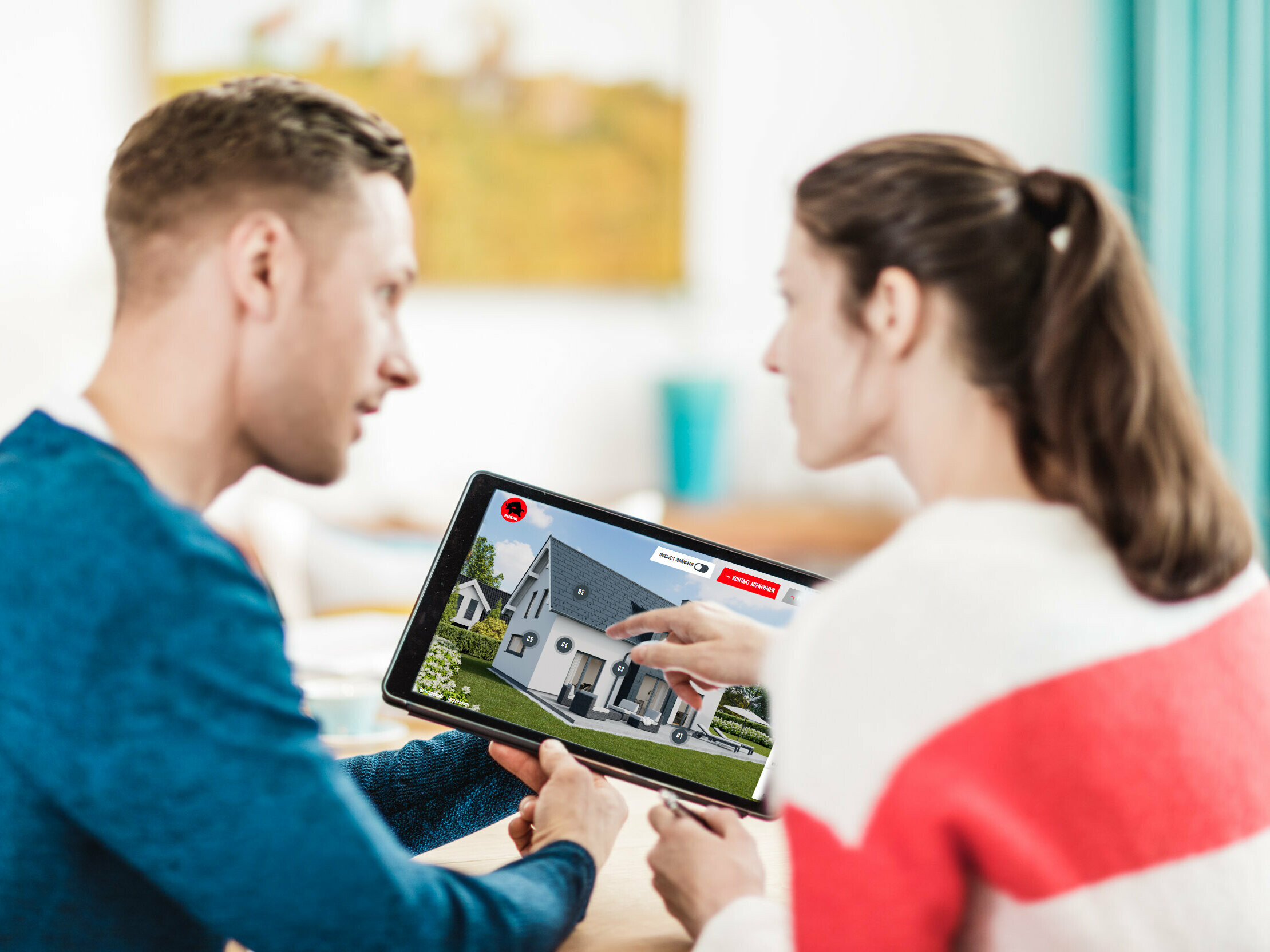 Un couple tient une tablette à la main, sur laquelle on peut voir le configurateur de toiture et de façade PREFA.