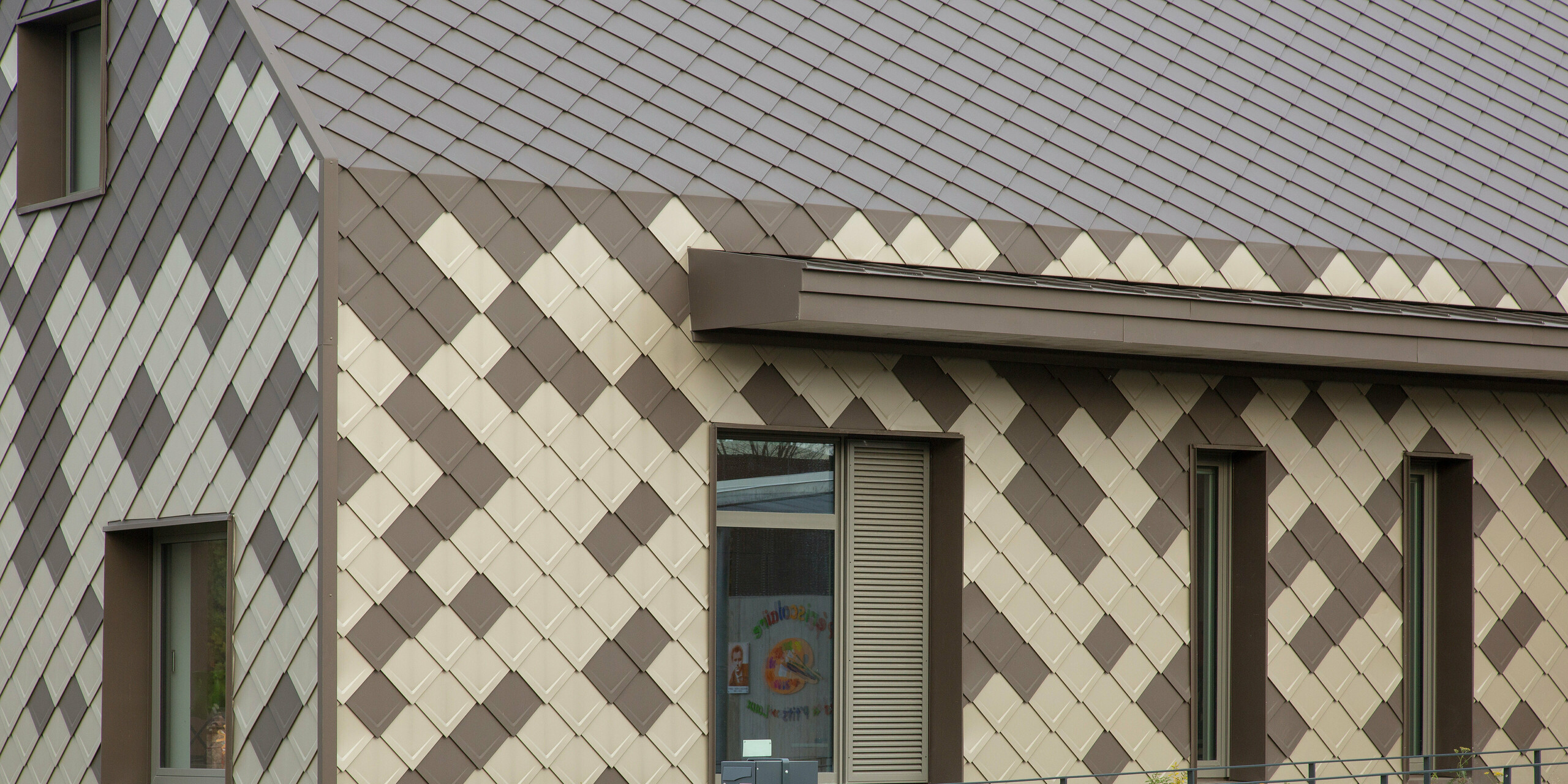 Du sol au toit, le périscolaire de Sessenheim est habillée en aluminium dans les couleurs brun et bronze.