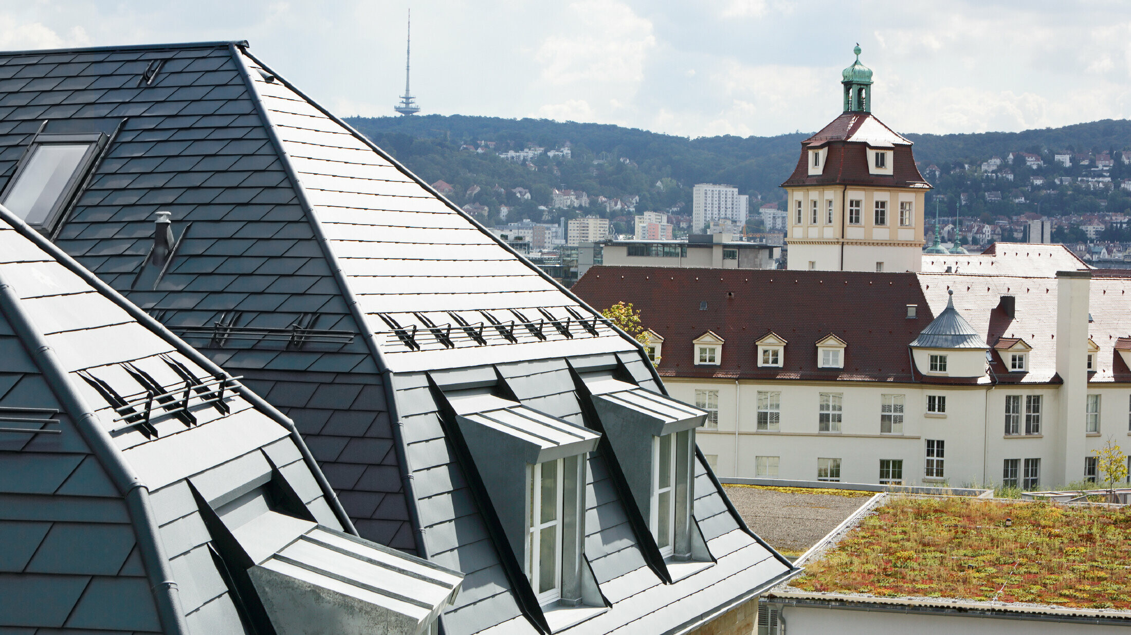 Maison de ville ancienne à Stuttgart, avec toit mansardé recouvert de bardeaux en aluminium PREFA en P.10 anthracite et nombreuses fenêtres-lucarnes