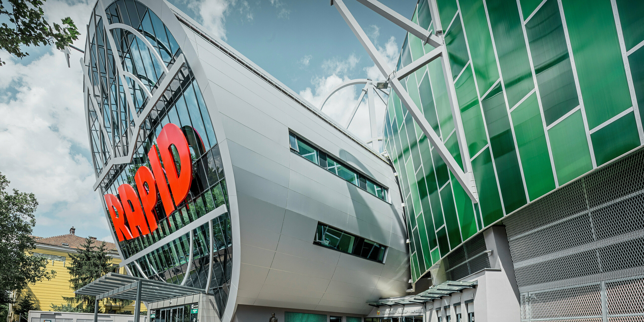 Das Allianz Stadion des SK Rapid Wien, gekennzeichnet durch eine imposante Röhre im Eingangsbereich. Die Röhre misst einen Durchmesser von 20 Meter. Die spektakuläre Fassade der Röhre ist mit PREFA Aluminium Verbundplatten in Silbermetallic verkleidet. Die Aluminiumhülle verleiht der Struktur ein futuristisches Design, das Technologie und Sportgeist in harmonischer Architektur vereint.