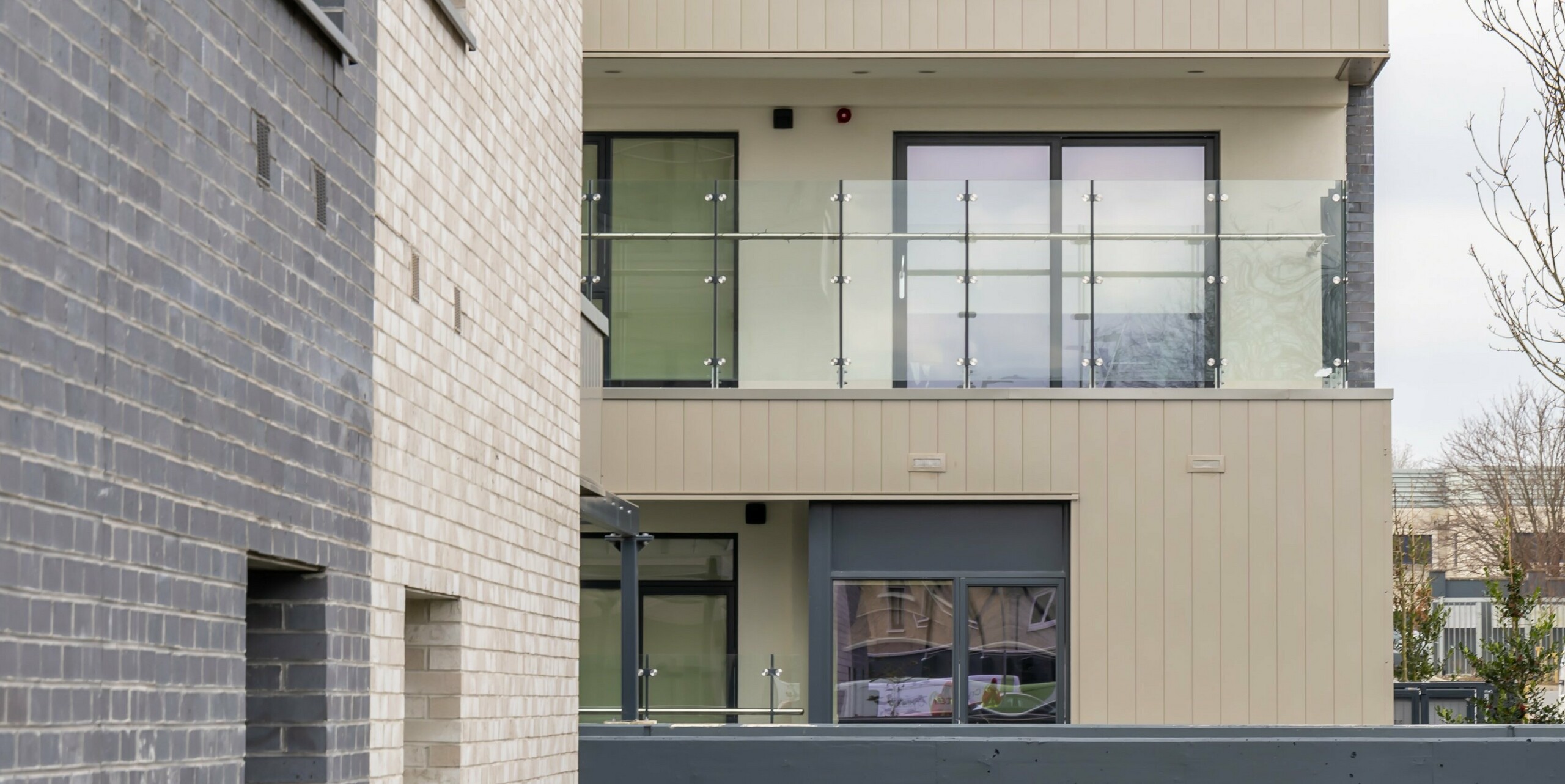 Vue détaillée de la façade du complexe résidentiel Palmers Gate à Palmerstown, Dublin, Irlande. L'image montre la combinaison de produits en aluminium PREFA de couleur bronze et d'éléments en brique. Les balcons sont équipés de balustrades en verre et offrent une qualité de vie moderne. L'enveloppe extérieure se compose d'environ 1 700 m² de revêtement PREFA et d'environ 1 200 m² de système de façade PREFALZ. L'image met en valeur les détails architecturaux et le choix de matériaux de haute qualité qui contribuent à la conception esthétique et fonctionnelle des bâtiments.