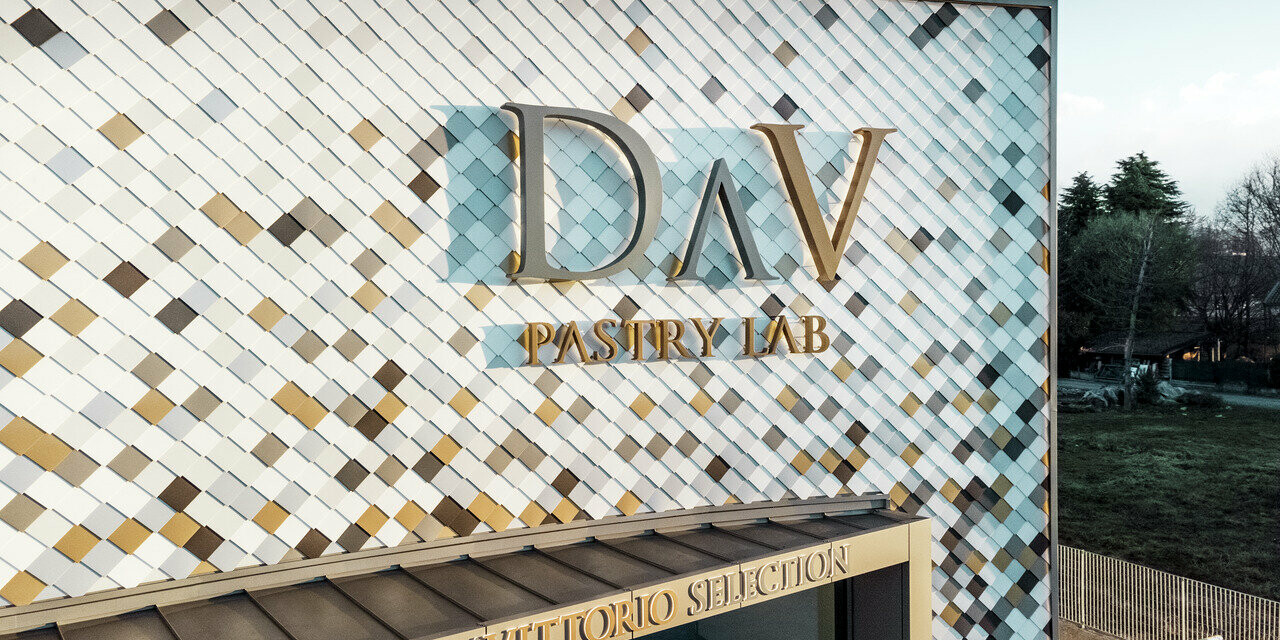 Bedrijfsgebouw van DAV Pastry Lab in Bergamo met gespikkelde losangegevel in de kleuren P.10 bruin, brons, P.10 donkergrijs, mayagoud, blank naturel, P.10 prefawit en P.10 zuiver wit 