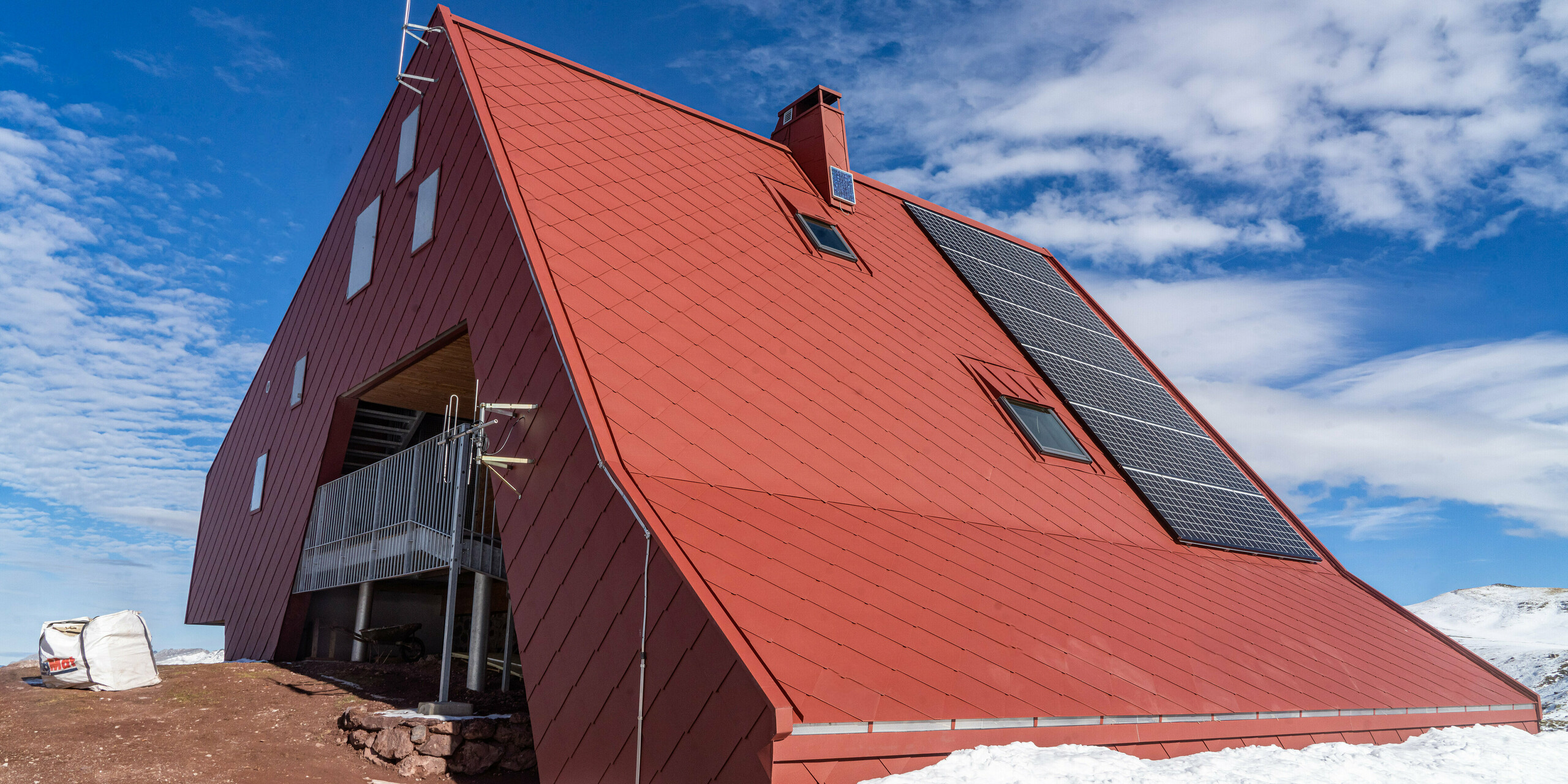 Refuge d'Arlet dans le Parc National des Pyrénées avec une coque de bâtiment en aluminium de couleur rouge oxyde