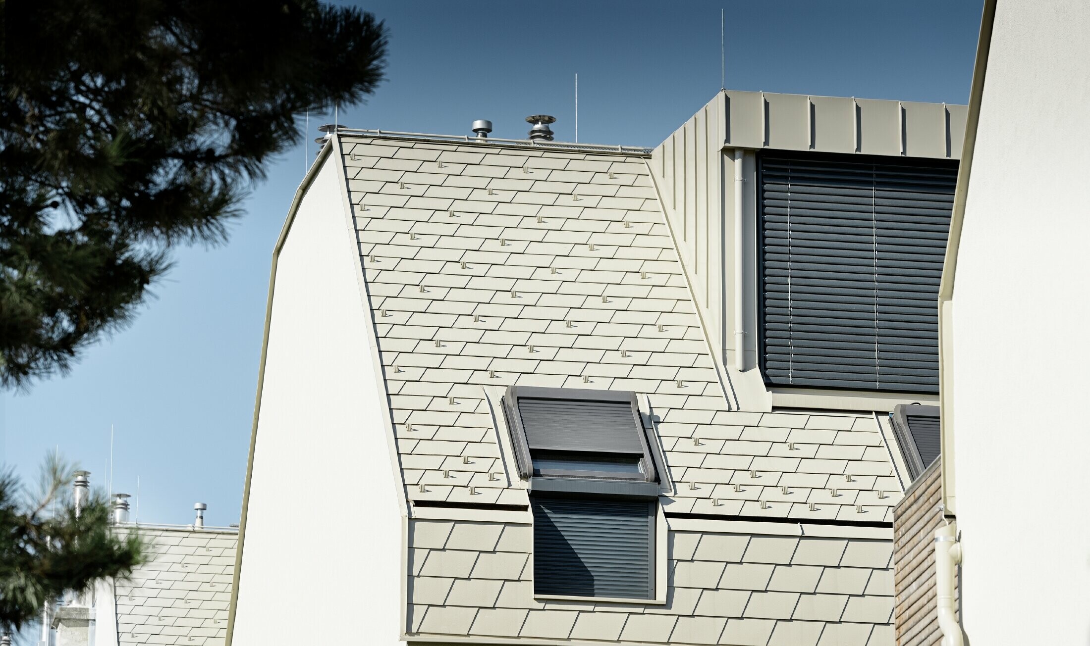 Nieuw woongebouw met groot aluminium dakvlak en talrijke dakvensters