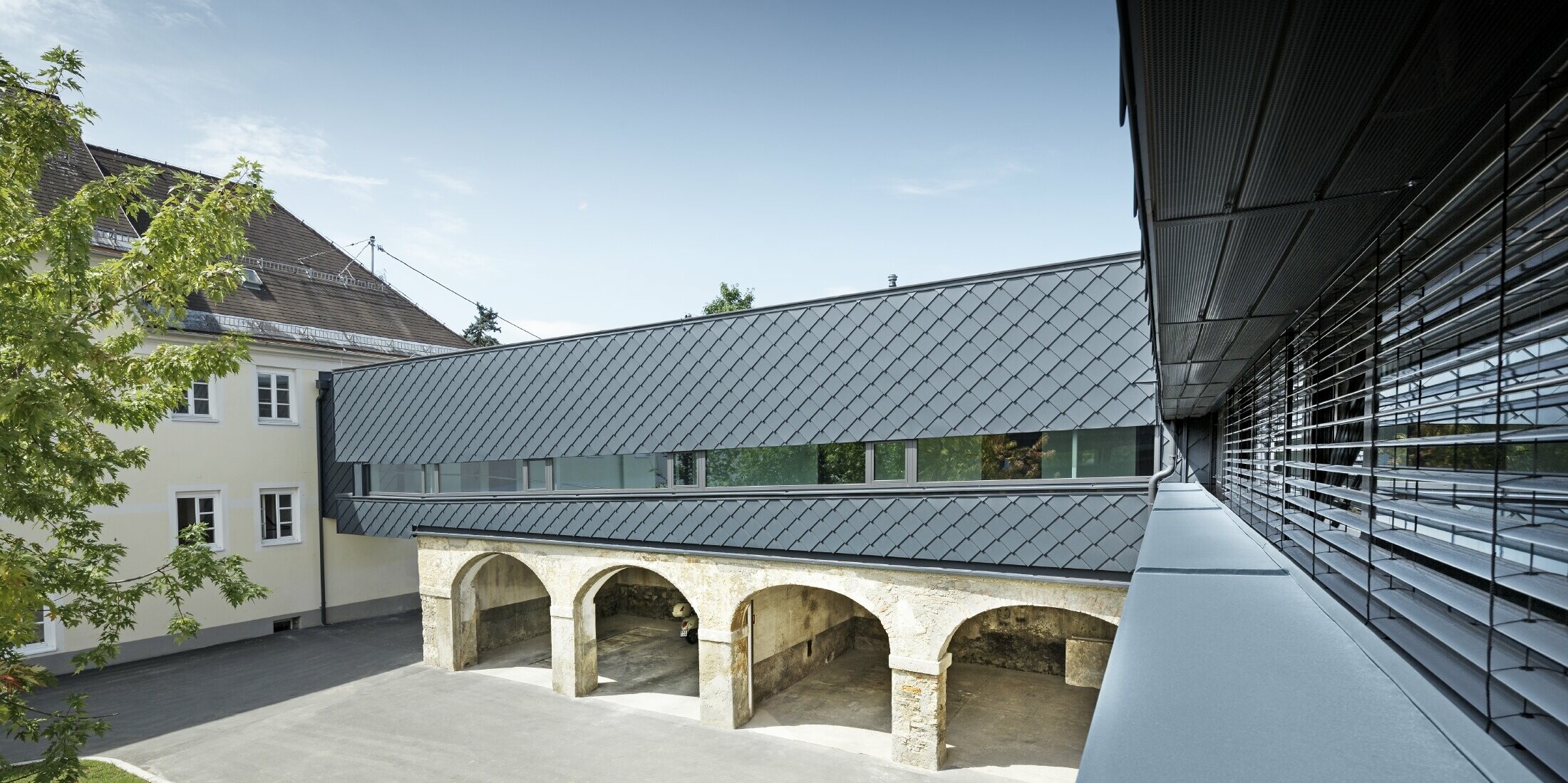 Denkmalgeschütztes Gebäude wurde im Obergeschoss mit der PREFA Wandraute 29 in Anthrazit verkleidet, so harmonieren die alten Strukturen im Erdgeschoss perfekt mit den neuen Rauten.