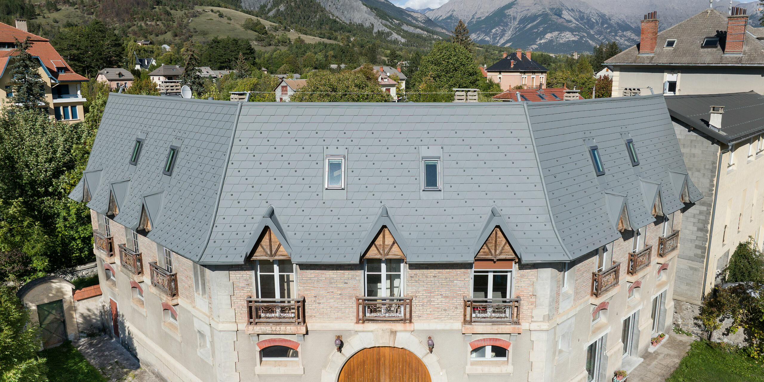 La vaste toiture d'une propriété à Barcelonnette, en France, a été rénovée avec le bardeau de toiture PREFA en P.10 gris souris.