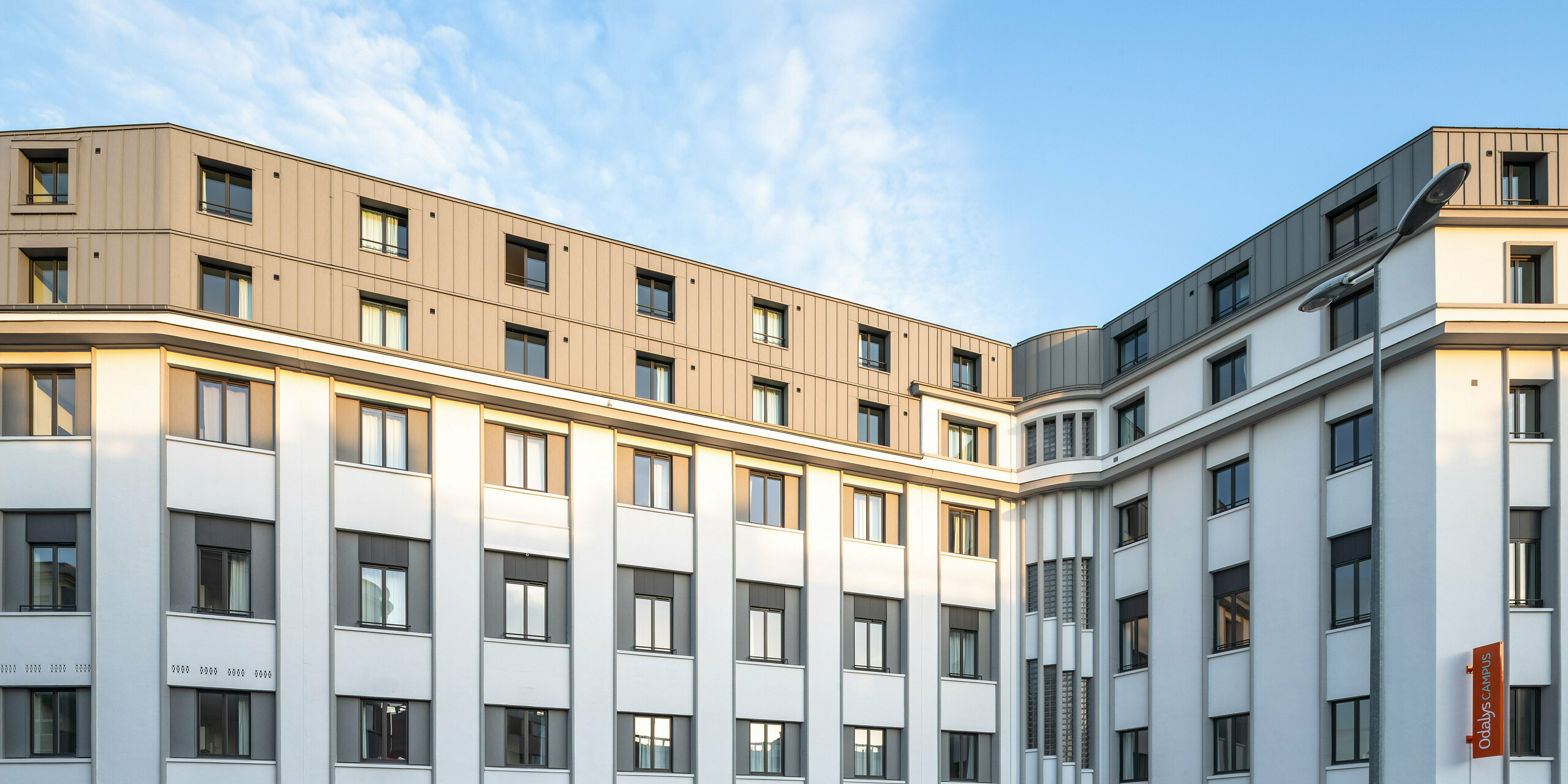 La forme particulière du bâtiment d'une résidence étudiante au Mans est recouverte de PREFALZ en gris quartz au niveau des étages supérieurs.