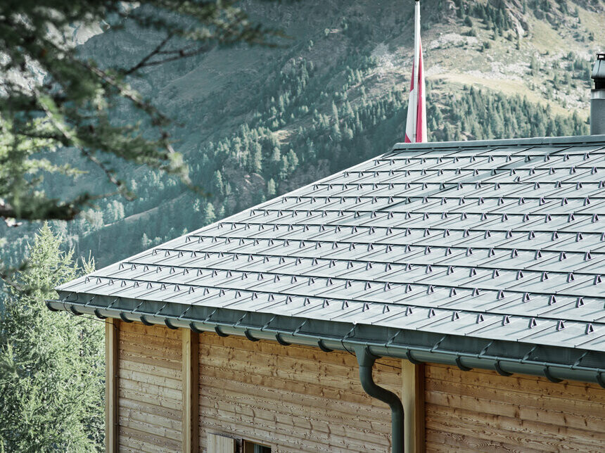 Zwitserse hut bedekt met de PREFA dakpan en met de PREFA hanggoot, die met de bovenbeugel bevestigd is.