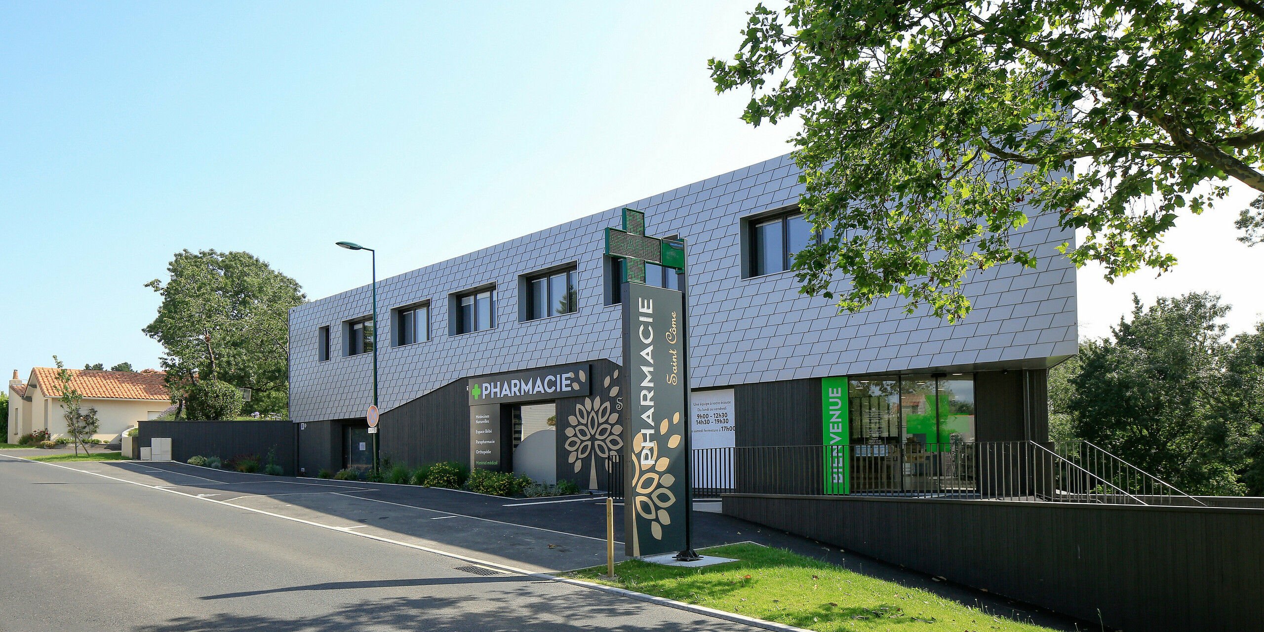 Accès à la pharmacie au rez-de-chaussée du centre de santé du Landreau avec une façade en bardeaux PREFA couleur argent métallisé