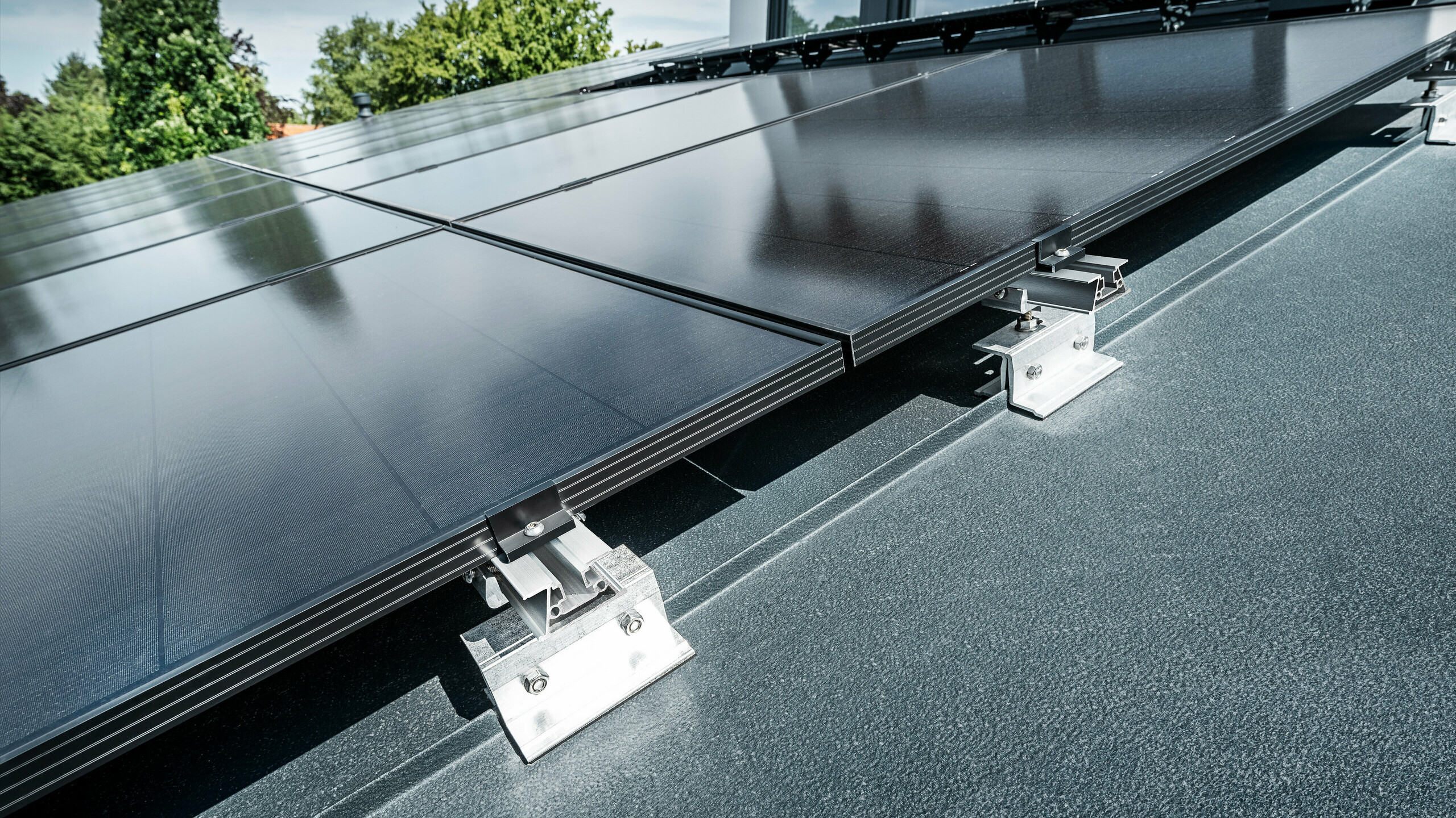 Photo rapprochée du système de montage solaire PREFALZ Vario Gros plan sur le support solaire PREFA PREFALZ Vario sur un toit à joint debout en anthracite