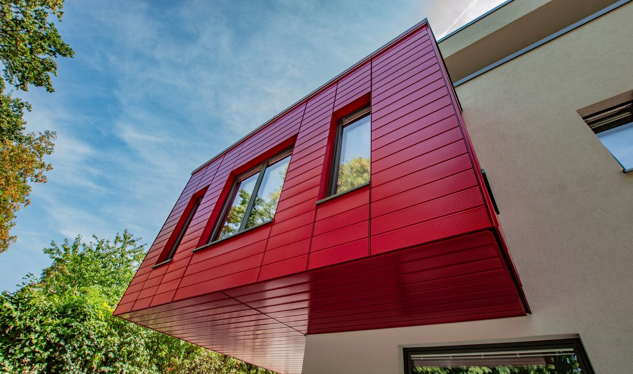 Erker met de PREFA sidings gelinieerd in robijnrood bekleed, sidings zijn horizontaal gemonteerd.