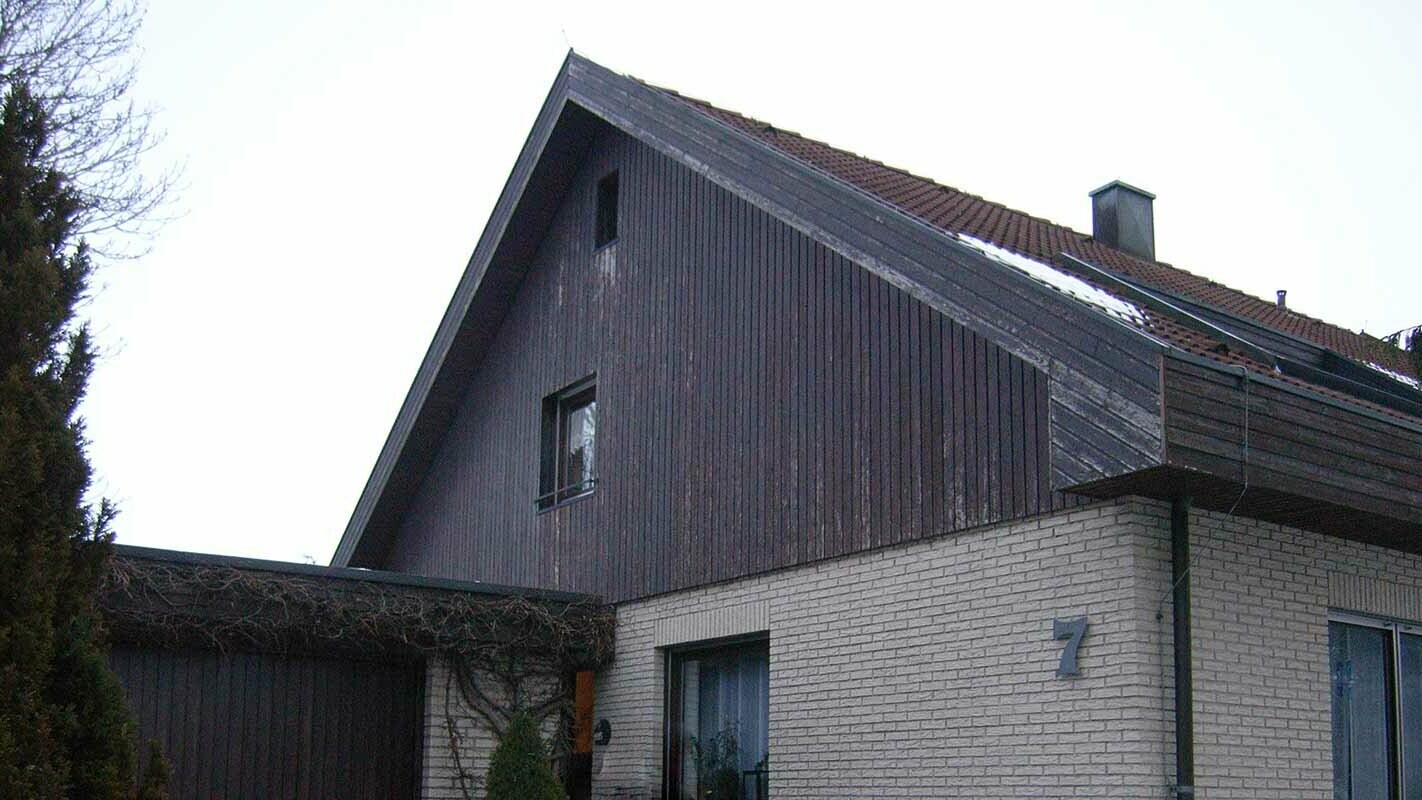 Oude topgevelbekleding met verweerd hout voor de renovatie met PREFA gevelbeplating