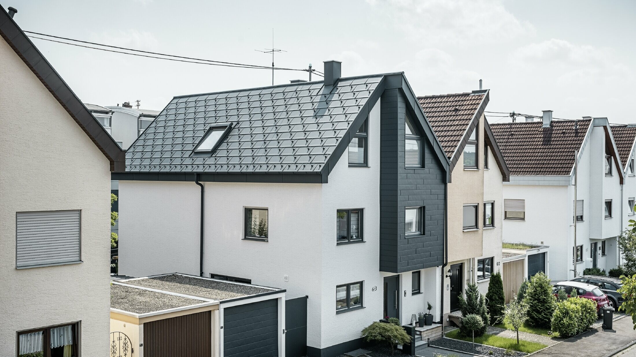 De helft van een twee-onder-een-kapwoning werd al gerenoveerd, met een frisse witte pleistergevel gecombineerd met een PREFA Siding.X gevel in antraciet. Het dak werd bedekt met de PREFA dakpan R.16. Het dakafvoersysteem bestaat uit de vierkante bakgoot inclusief PREFA afvoerbuis.