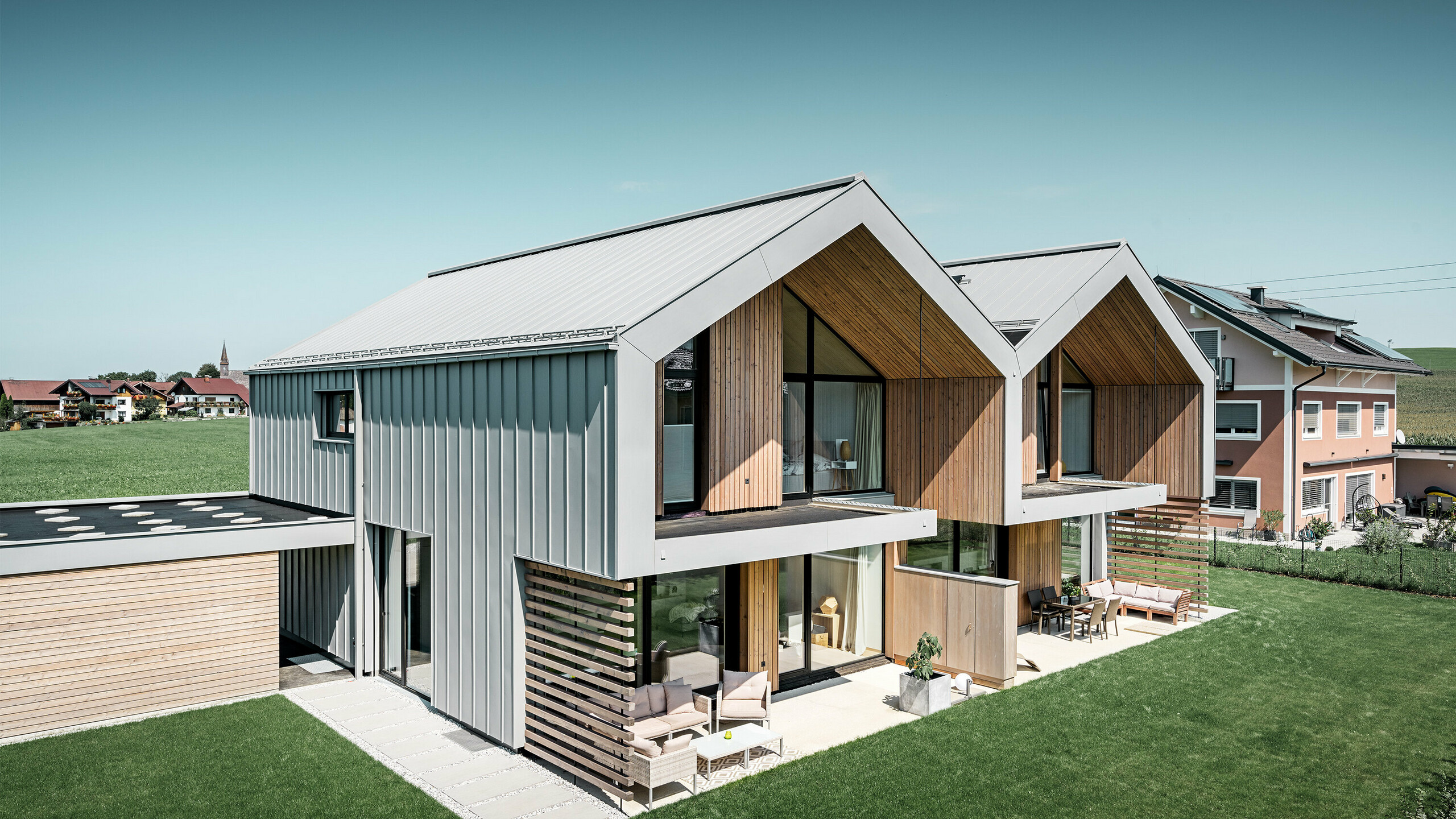 Maisons jumelées modernes avec enveloppe de bâtiment PREFALZ, le toit et la façade sont habillés de PREFALZ couleur gris quartz, tuyau de descente carré compris