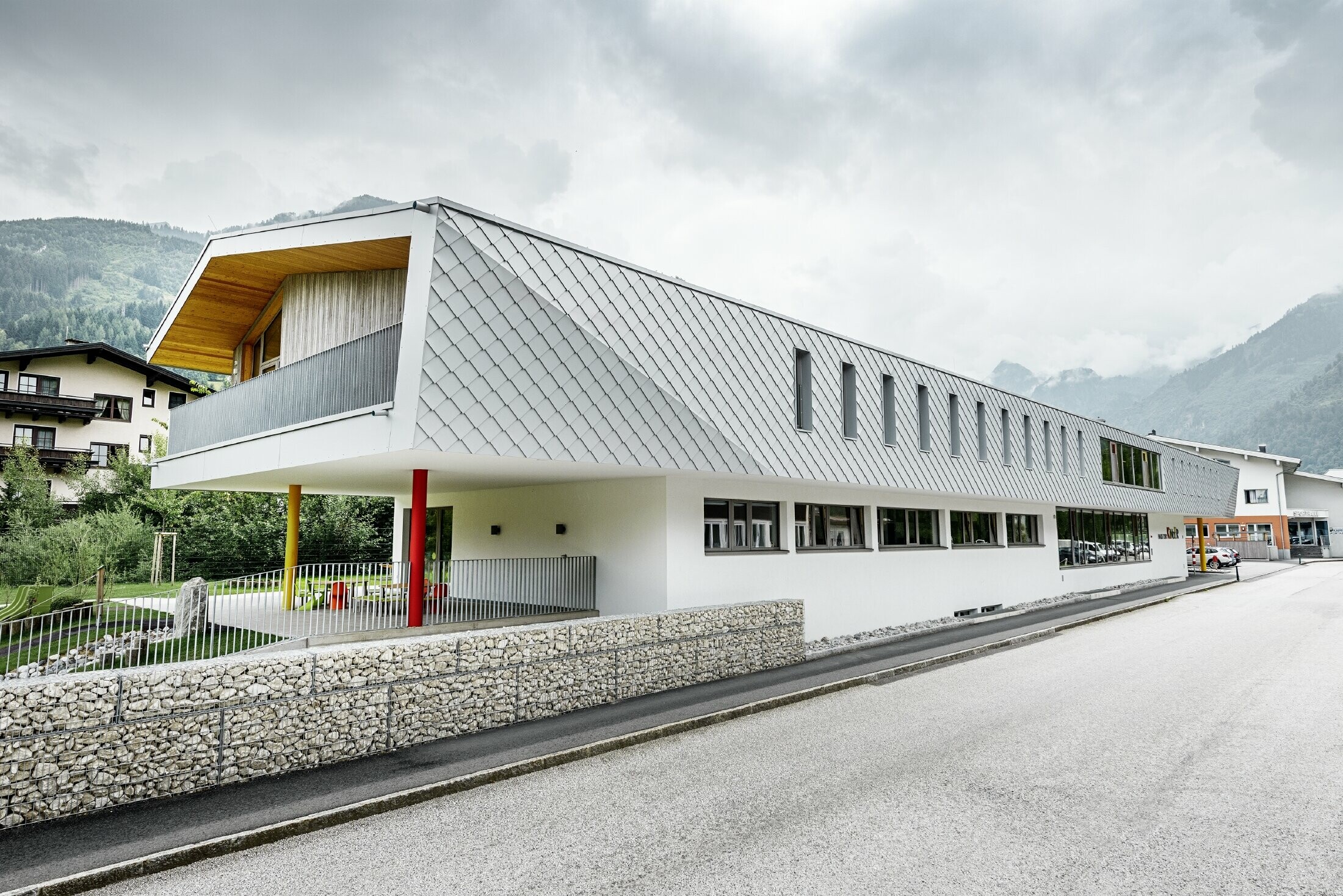 Nouvelle école maternelle de Kaprun — Façade moderne en aluminium réalisée avec des losanges de façade PREFA couleur blanc prefa