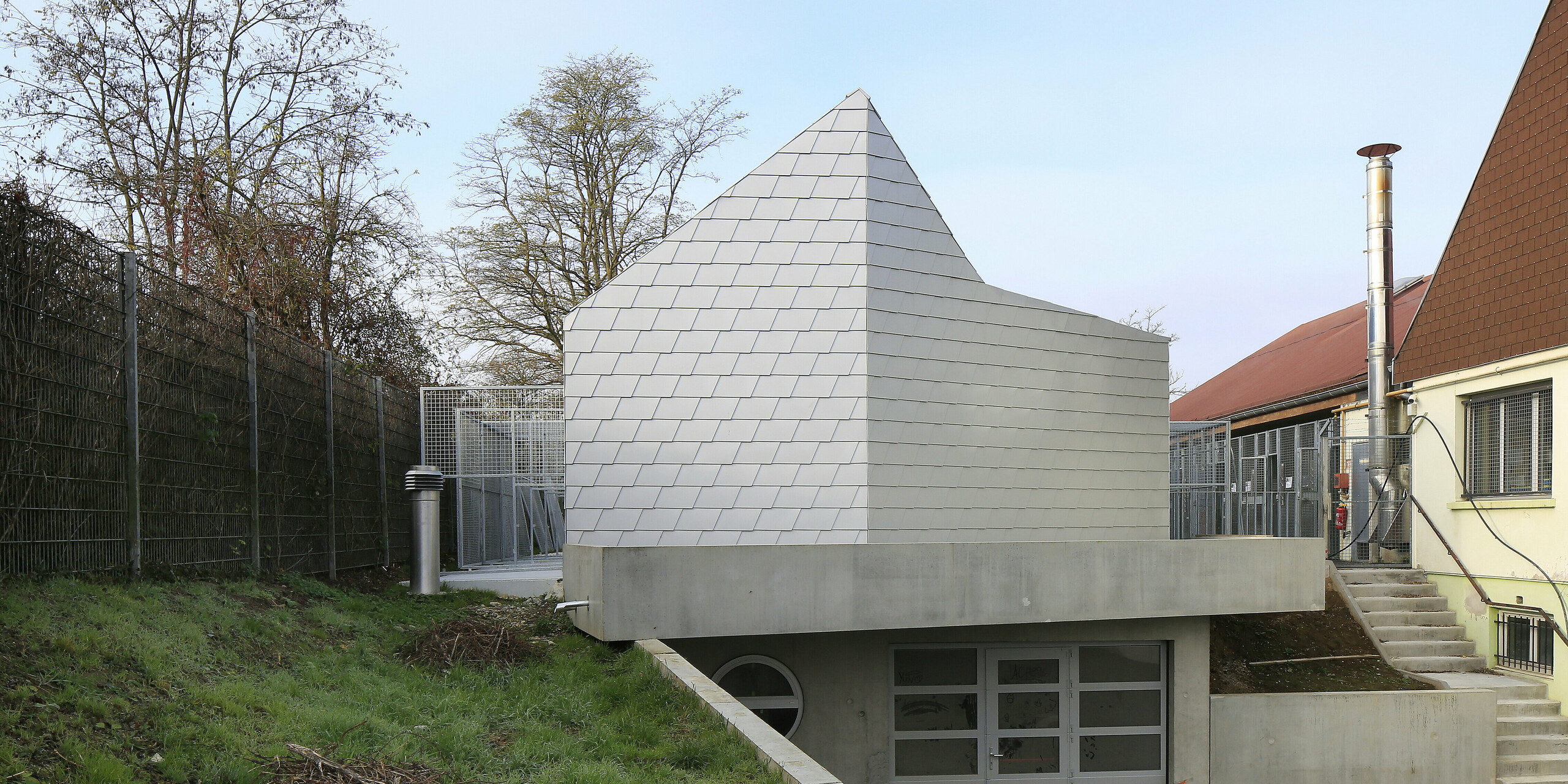 Accès à l'association de protection des animaux de Mullhouse avec une coque de bâtiment attrayante en bardeaux de toiture et de façade PREFA en argent métallisé